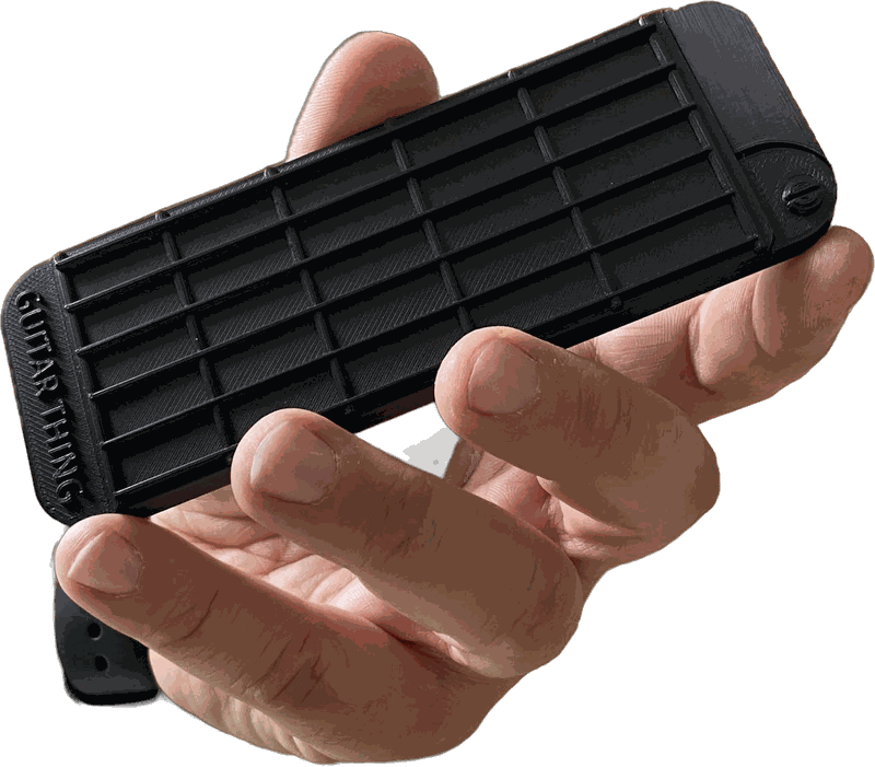 Hand holding a closed Guitar Thing, a black pocket-sized guitar fretboard with "Guitar Thing" on its end